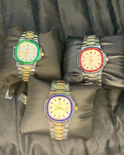 Three watches with colorful faces on gray cushions