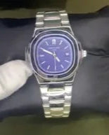 Silver watch with a blue face on a dark purple cushion, held by a gloved hand.