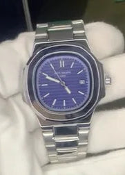 Silver watch with a blue face held by a gloved hand