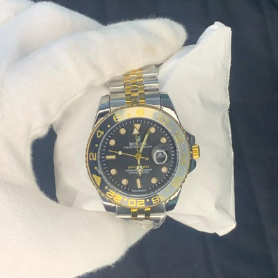 Rolex watch with black dial and gold accents on a white cushion