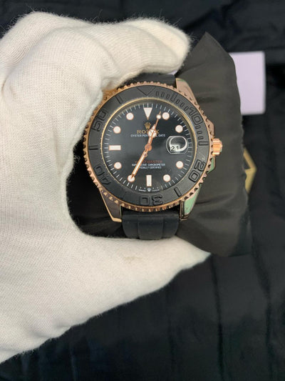 Black and rose gold watch held by a gloved hand
