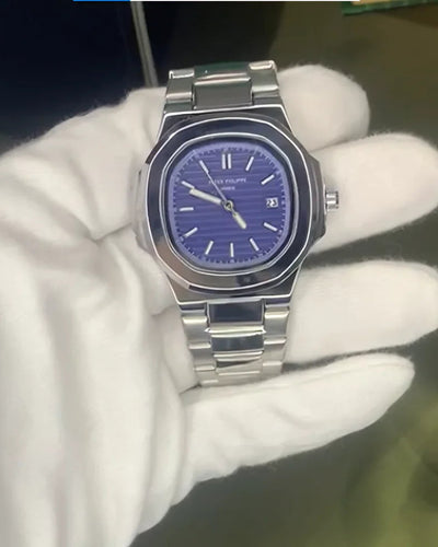 Silver watch with blue face held by a gloved hand